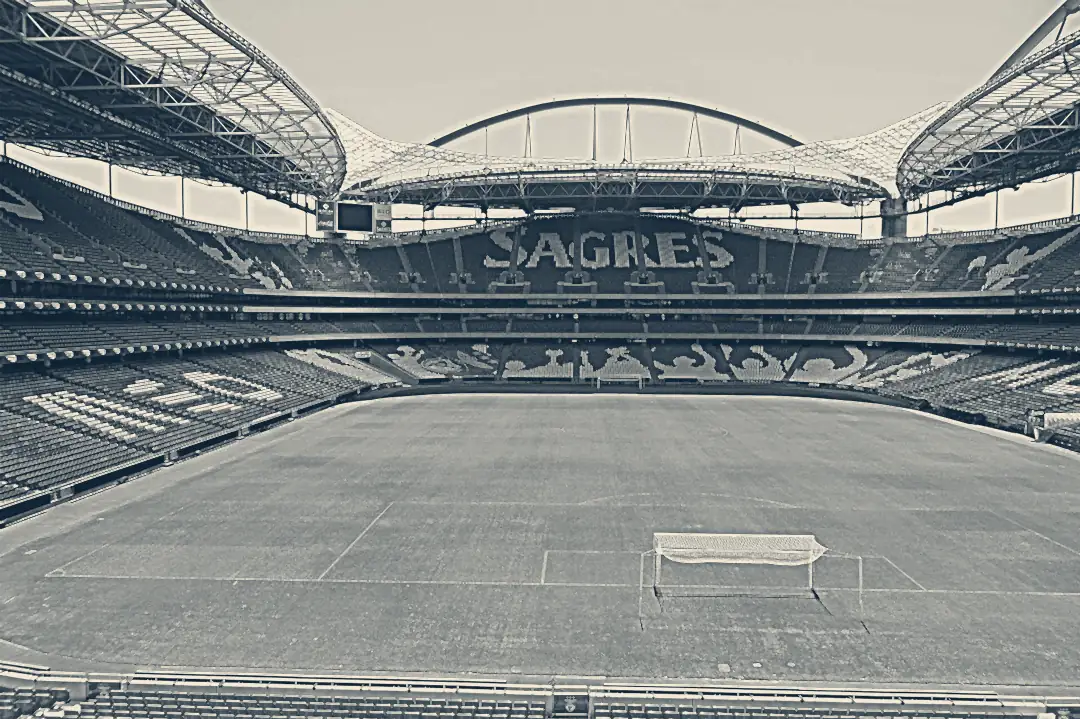 Interior do Estádio da Luz com o relvado cortado às riscas e a baliza em primeiro plano
